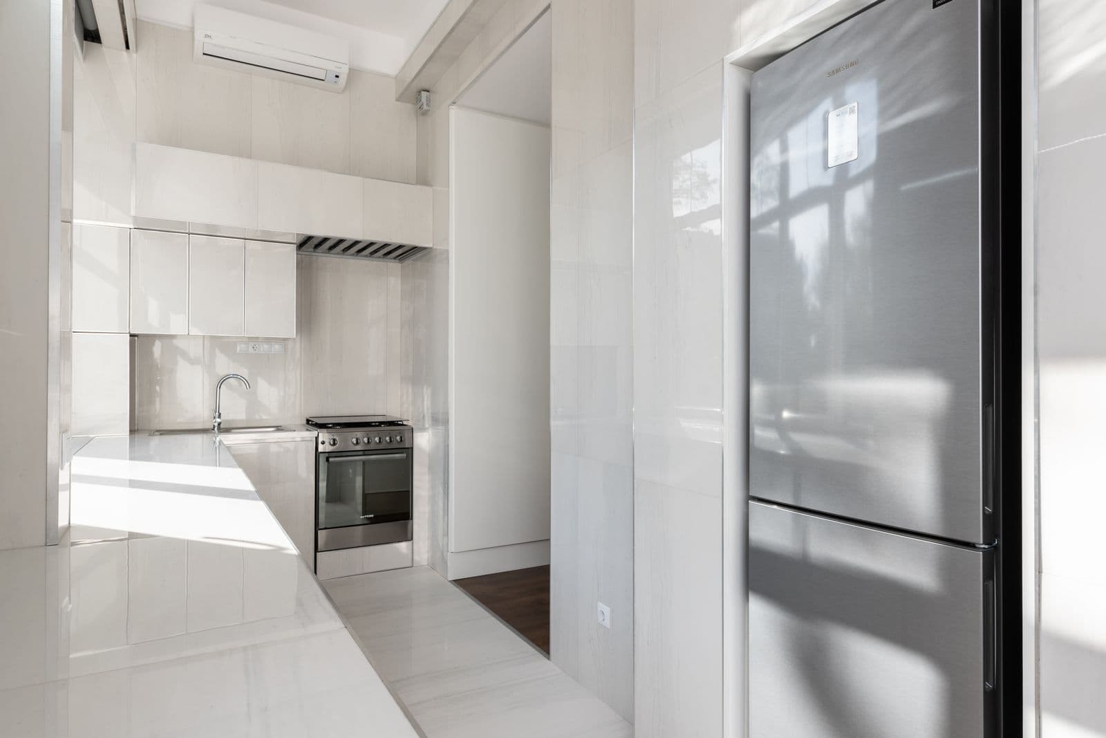 Cocina con mesada blanca y heladera